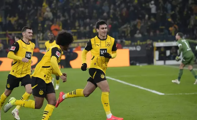 Dortmund's Giovanni Reyna, right, celebrates after scoring the opening goal during the German Bundesliga soccer match between Borussia Dortmund and TSG Hoffenheim at the Signal-Iduna Park in Dortmund, Germany, Sunday, Dec. 15 2024. (AP Photo/Martin Meissner)