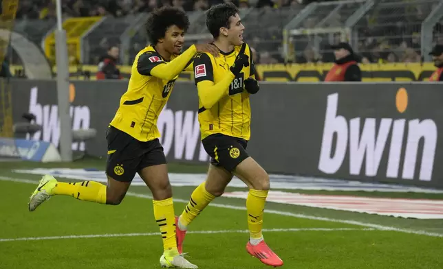 Dortmund's Giovanni Reyna, right, celebrates with teammate Karim Adeyemi after scoring the opening goal during the German Bundesliga soccer match between Borussia Dortmund and TSG Hoffenheim at the Signal-Iduna Park in Dortmund, Germany, Sunday, Dec. 15 2024. (AP Photo/Martin Meissner)