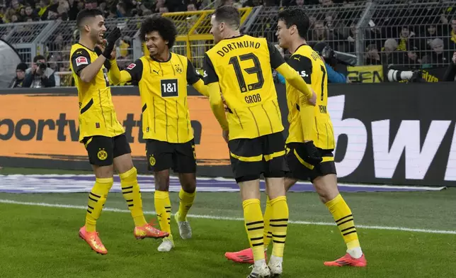 Dortmund's Giovanni Reyna, right, celebrates with teammates after scoring the opening goal during the German Bundesliga soccer match between Borussia Dortmund and TSG Hoffenheim at the Signal-Iduna Park in Dortmund, Germany, Sunday, Dec. 15 2024. (AP Photo/Martin Meissner)