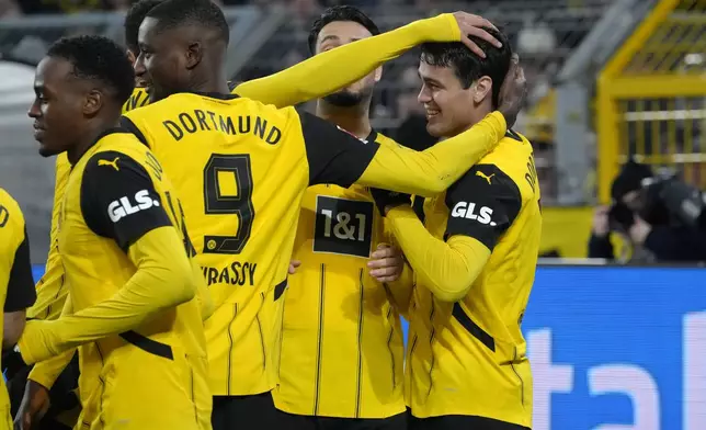 Dortmund's Giovanni Reyna, right, celebrates with teammates after scoring the opening goal during the German Bundesliga soccer match between Borussia Dortmund and TSG Hoffenheim at the Signal-Iduna Park in Dortmund, Germany, Sunday, Dec. 15 2024. (AP Photo/Martin Meissner)