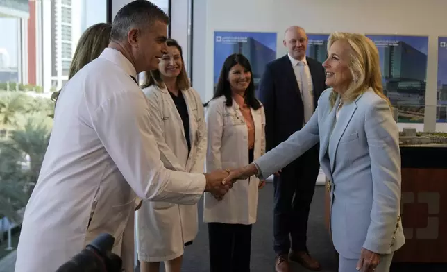 First lady Jill Biden, right, meets medical staff at Cleveland Clinic in Abu Dhabi, United Arab Emirates, Thursday, Dec. 5, 2024. (AP Photo/Altaf Qadri)