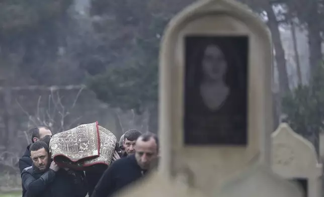 People carry the body of Mahammadali Eganov, 13 who died in the Azerbaijan Airlines Embraer 190 crash near Kazakhstan's Aktau airport, at his funeral, in Baku, Azerbaijan, Saturday, Dec. 28, 2024. (AP Photo)