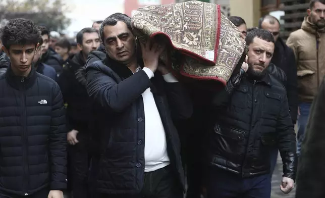 People attend a funeral of Mahammadali Eganov who died in the Azerbaijan Airlines Embraer 190 crash near the Kazakhstan's airport of Aktau at the age of 13, in Baku, Azerbaijan, Saturday, Dec. 28, 2024. (AP Photo)