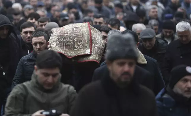 People attend the funeral of Mahammadali Eganov, 13 who died in the Azerbaijan Airlines Embraer 190 crash near Kazakhstan's Aktau airport, in Baku, Azerbaijan, Saturday, Dec. 28, 2024. (AP Photo)