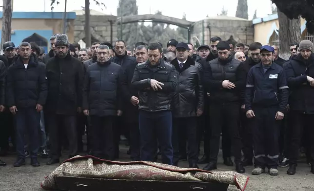 People attend a funeral of Mahammadali Eganov, 13 who died in the Azerbaijan Airlines Embraer 190 crash near Kazakhstan's Aktau airport, in Baku, Azerbaijan, Saturday, Dec. 28, 2024. (AP Photo)