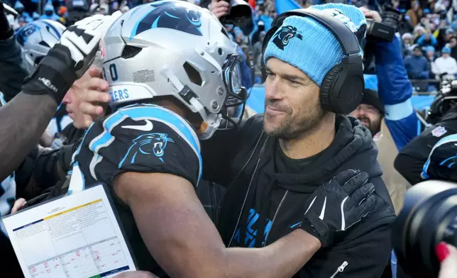 Carolina Panthers running back Chuba Hubbard hugs head coach Dave Canales after scoring the winning touchdown against the Arizona Cardinals during overtime of an NFL football game, Sunday, Dec. 22, 2024, in Charlotte, N.C. (AP Photo/Rusty Jones)