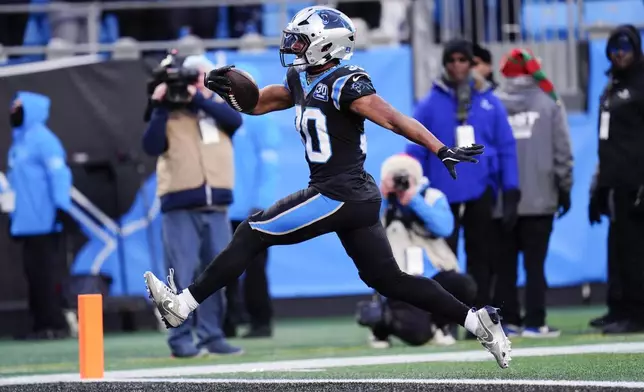 Carolina Panthers running back Chuba Hubbard scores the winning touchdown against the Arizona Cardinals during overtime of an NFL football game, Sunday, Dec. 22, 2024, in Charlotte, N.C. (AP Photo/Rusty Jones)