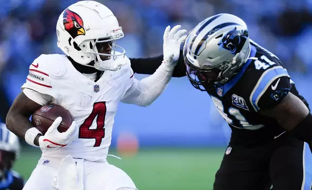 Arizona Cardinals wide receiver Greg Dortch runs by Carolina Panthers linebacker Jacoby Windmon during the second half of an NFL football game, Sunday, Dec. 22, 2024, in Charlotte, N.C. (AP Photo/Rusty Jones)