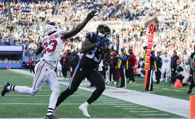 Carolina Panthers wide receiver David Moore catches a touchdown pass ahead of Arizona Cardinals cornerback Sean Murphy-Bunting during the second half of an NFL football game, Sunday, Dec. 22, 2024, in Charlotte, N.C. (AP Photo/Rusty Jones)