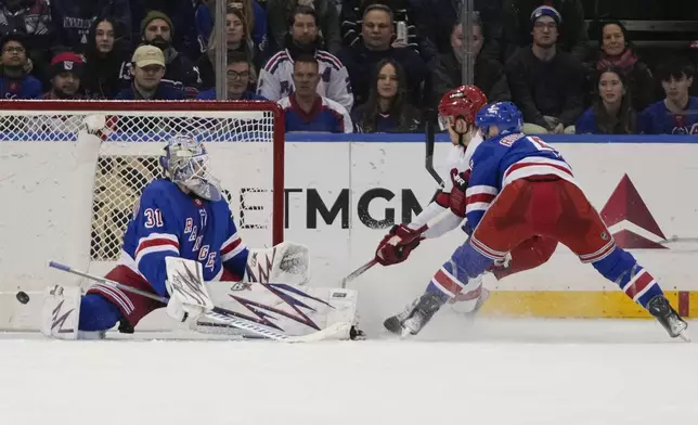 Carolina Hurricanes' Jack Roslovic (96) shoots the puck past New York Rangers goaltender Igor Shesterkin (31) for a goal during the second period of an NHL hockey game Sunday, Dec. 22, 2024, in New York. (AP Photo/Frank Franklin II)