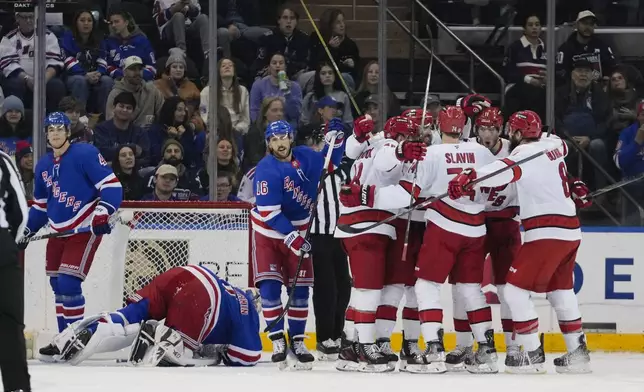 The Carolina Hurricanes celebrate a goal by William Carrier as New York Rangers' Braden Schneider (4), Vincent Trocheck (16) and goaltender Igor Shesterkin react during the second period of an NHL hockey game Sunday, Dec. 22, 2024, in New York. (AP Photo/Frank Franklin II)