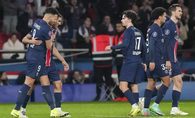 PSG's Goncalo Ramos, left, celebrates with teammates after scoring his side's third goal during the French League One soccer match between Paris Saint-Germain and Lyon at the Parc des Princes in Paris, Sunday, Dec. 15, 2024. (AP Photo/Aurelien Morissard)