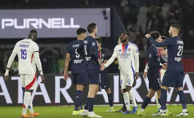 Lyon's Ainsley Maitland-Niles, center, and Lyon's Moussa Niakhate react at the end of the French League One soccer match between Paris Saint-Germain and Lyon at the Parc des Princes in Paris, Sunday, Dec. 15, 2024. (AP Photo/Aurelien Morissard)