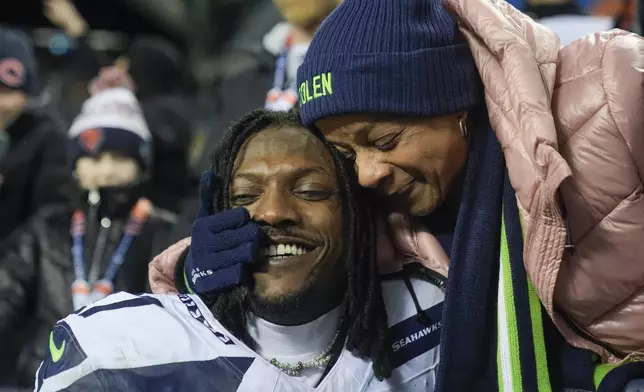 Seattle Seahawks cornerback Riq Woolen, left, shares a moment with his mother following an NFL football game against the Chicago Bears, Thursday, Dec. 26, 2024, in Chicago. The Seahawks won 6-3. (AP Photo/Erin Hooley)