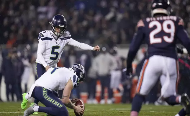 Seattle Seahawks place kicker Jason Myers (5), with Michael Dickson holding, kicks a field goal against the Chicago Bears during the first half of an NFL football game, Thursday, Dec. 26, 2024, in Chicago. (AP Photo/Erin Hooley)