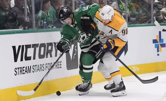 Nashville Predators center Ryan O'Reilly (90) and Dallas Stars center Wyatt Johnston (53) skate for control of the puck in the first period of an NHL hockey game Thursday, Dec. 12, 2024, in Dallas. (AP Photo/LM Otero)