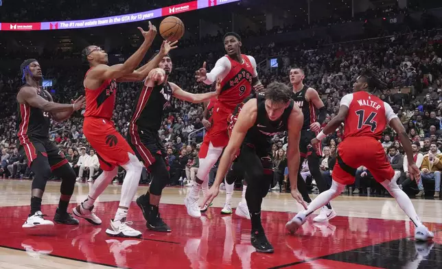 Toronto Raptors' RJ Barrett (9) and teammate Scottie Barnes, second from left, fight for a rebound during first-half NBA basketball game action against the Miami Heat in Toronto, Sunday, Dec. 1, 2024. (Chris Young/The Canadian Press via AP)