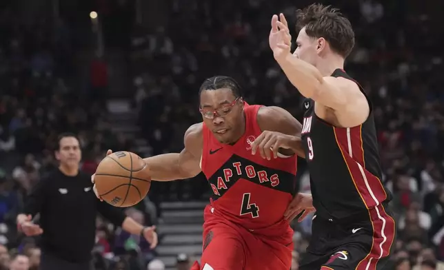 Toronto Raptors' Scottie Barnes (4) drives past Miami Heat's Pelle Larsson (9) during first-half NBA basketball game action in Toronto, Sunday, Dec. 1, 2024. (Chris Young/The Canadian Press via AP)