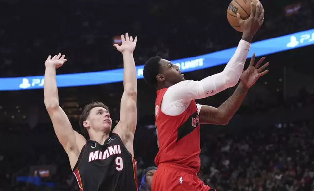 Toronto Raptors' RJ Barrett, right, drives to the net against Miami Heat's Pelle Larsson, left, during first-half NBA basketball game action in Toronto, Sunday, Dec. 1, 2024. (Chris Young/The Canadian Press via AP)