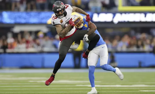 Tampa Bay Buccaneers wide receiver Mike Evans (13) is tackled by Los Angeles Chargers cornerback Tarheeb Still during the second half of an NFL football game Sunday, Dec. 15, 2024, in Inglewood, Calif. (AP Photo/Ryan Sun)