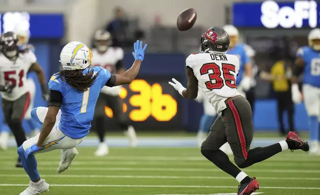 Tampa Bay Buccaneers cornerback Jamel Dean (35) intercepts a pass intended for Los Angeles Chargers wide receiver Quentin Johnston (1) during the second half of an NFL football game Sunday, Dec. 15, 2024, in Inglewood, Calif. (AP Photo/Eric Thayer)