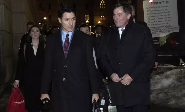 Canada's Prime Minister Justin Trudeau makes his way way his new Finance Minister, Dominic LeBlanc to a national caucus meeting, in Ottawa, Ontario, Monday, Dec. 16, 2024. (Adrian Wyld/The Canadian Press via AP)