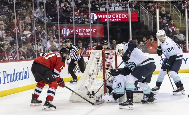 Seattle Kraken goalie Philipp Grubauer (31) saves a shot from New Jersey Devils right wing Stefan Noesen (11) during the second period of an NHL hockey game, Friday, Dec. 6, 2024, in Newark, N.J. (AP Photo/Stefan Jeremiah)