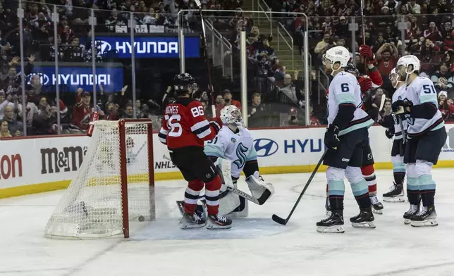 Seattle Kraken goalie Philipp Grubauer (31) looks up in disappointment as the New Jersey Devils score a goal during the second period of an NHL hockey game, Friday, Dec. 6, 2024, in Newark, N.J. (AP Photo/Stefan Jeremiah)