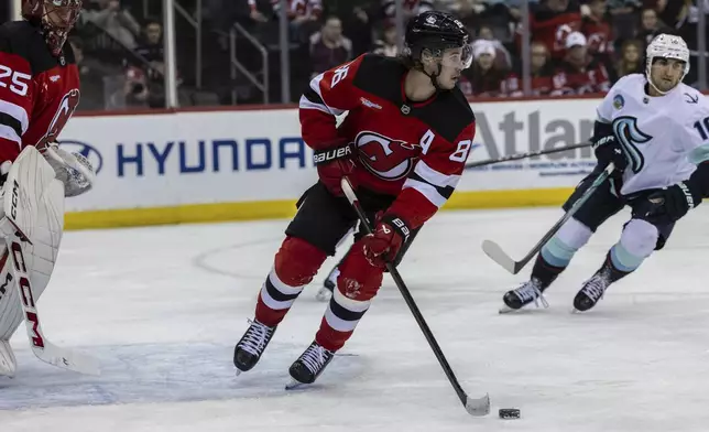 New Jersey Devils center Jack Hughes (86) moves the puck against the Seattle Kraken during the first period of an NHL hockey game, Friday, Dec. 6, 2024, in Newark, N.J. (AP Photo/Stefan Jeremiah)