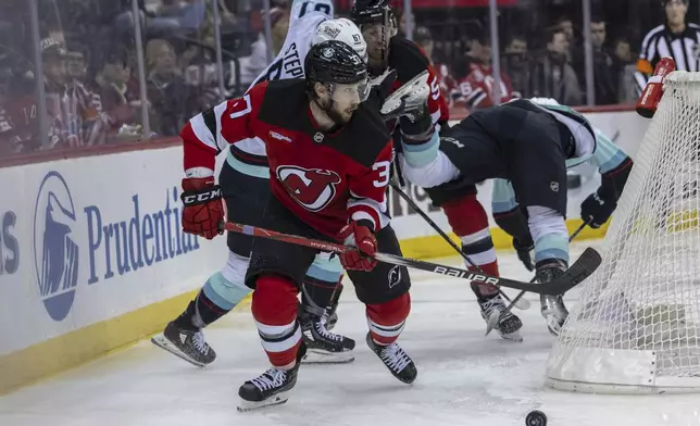 New Jersey Devils center Justin Dowling moves the puck against the Seattle Kraken during the first period of an NHL hockey game, Friday, Dec. 6, 2024, in Newark, N.J. (AP Photo/Stefan Jeremiah)