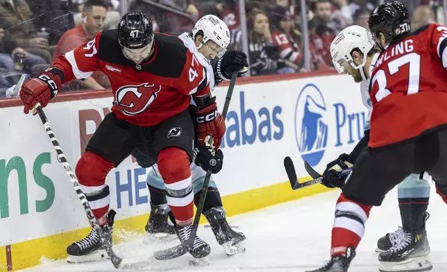 New Jersey Devils center Paul Cotter (47) fights for the puck during the second period of an NHL hockey game against the Seattle Kraken, Friday, Dec. 6, 2024, in Newark, N.J. (AP Photo/Stefan Jeremiah)