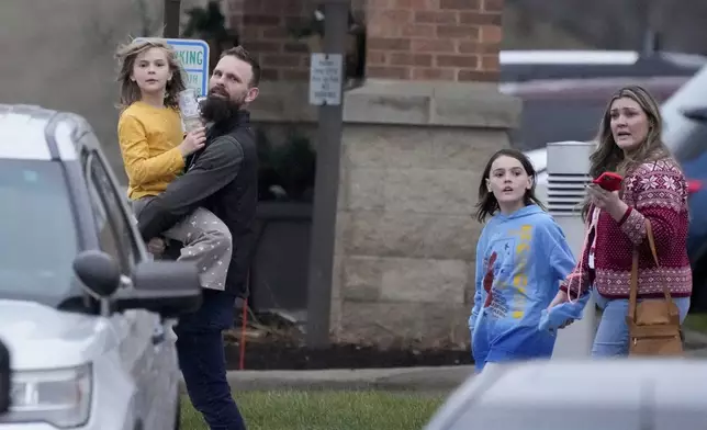 Families leave the SSMI Health Center, set up as a reunification center, following a shooting, Monday, Dec. 16, 2024 in Madison, Wis. (AP Photo/Morry Gash)