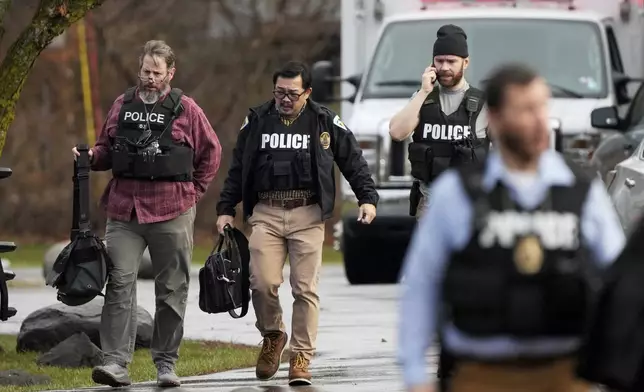 Police walk outside the Abundant Life Christian School following a shooting, Monday, Dec. 16, 2024 in Madison, Wis. (AP Photo/Morry Gash)