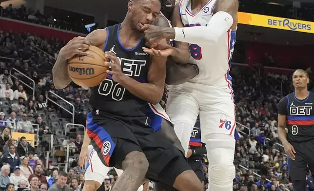 Detroit Pistons forward Ronald Holland II (00) is fouled by Philadelphia 76ers forward Paul George (8) during the first half of an NBA basketball game, Saturday, Nov. 30, 2024, in Detroit. (AP Photo/Carlos Osorio)