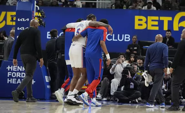 Philadelphia 76ers center Andre Drummond (5) is helped off the court after a play during the first half of an NBA basketball game against the Detroit Pistons, Saturday, Nov. 30, 2024, in Detroit. (AP Photo/Carlos Osorio)