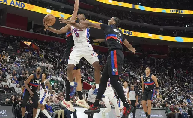 Philadelphia 76ers guard Tyrese Maxey (0) attempts a layup as Detroit Pistons forward Ausar Thompson (9) defends during the second half of an NBA basketball game, Saturday, Nov. 30, 2024, in Detroit. (AP Photo/Carlos Osorio)