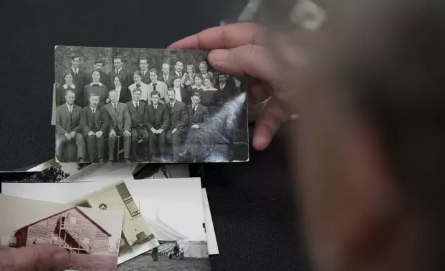 Pam Walton holds a photograph of “Two by Twos” ministers, also referred to as “workers,” at a library Monday, Dec. 9, 2004, in Wailea, Hawaii. Walton uses historic photos and other records to track the movements of spiritual leaders facing allegations of child sexual abuse within the sect. (AP Photo/Mengshin Lin)