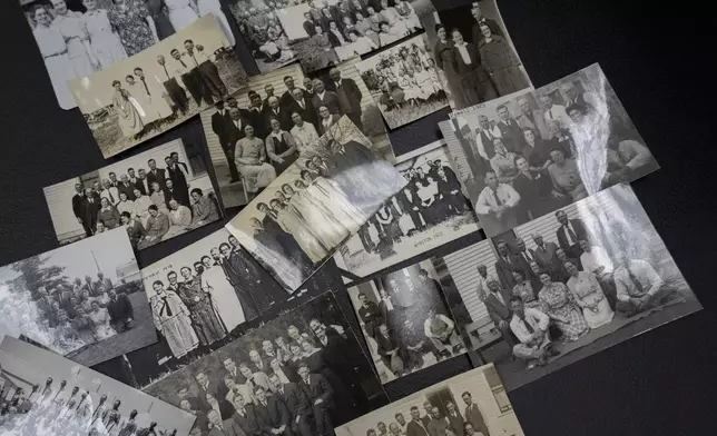 Photographs from annual “Two by Twos” sect conventions sit on a table at a library Monday, Dec. 9, 2024 in Wailea, Hawaii. Former sect member Pam Walton uses photos and other documents to track the movements of spiritual leaders facing child sex abuse allegations within the group. (AP Photo/Mengshin Lin)