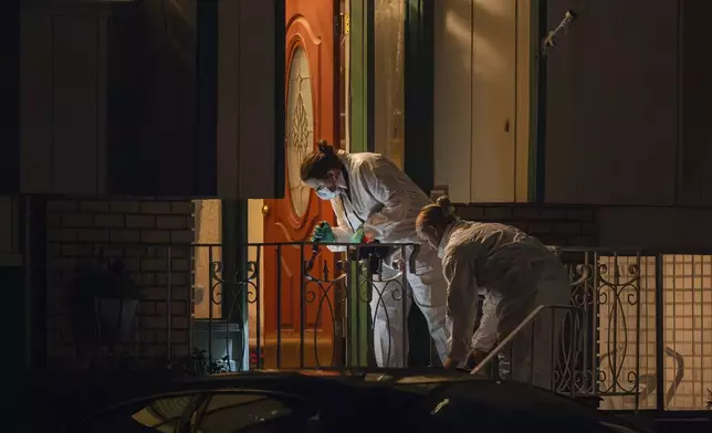 Technicians investigate a crime scene where police say multiple family members were found dead inside a home in West Valley City, Utah, Tuesday Dec. 17, 2024. (Scott G. Winterton/The Deseret News via AP)