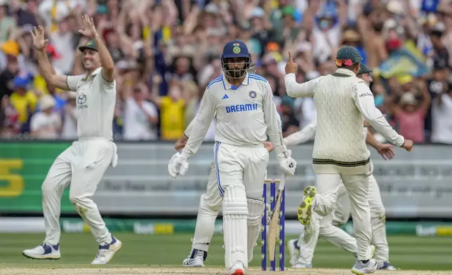 India's Jasprit Bumrah, center, walks off the field after losing his wicket as Australian players celebrate during play on the last day of the fourth cricket test between Australia and India at the Melbourne Cricket Ground, Melbourne, Australia, Monday, Dec. 30, 2024. (AP Photo/Asanka Brendon Ratnayake)