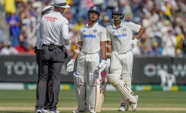 India's Yashasvi Jaiswal, center, speaks to umpires after being dismissed during play on the last day of the fourth cricket test between Australia and India at the Melbourne Cricket Ground, Melbourne, Australia, Monday, Dec. 30, 2024. (AP Photo/Asanka Brendon Ratnayake)