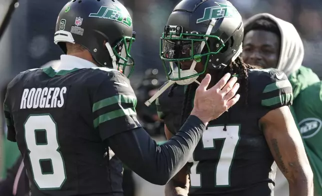 New York Jets quarterback Aaron Rodgers (8) congratulates wide receiver Davante Adams (17) after Adams caught a touchdown pass from Rodgers against the Seattle Seahawks during the first quarter of an NFL football game, Sunday, Dec. 1, 2024, in East Rutherford, N.J. (AP Photo/Seth Wenig)