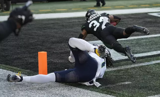 New York Jets running back Kene Nwangwu (34) dives into the end zone to score a touchdown after running back a kickoff 99 yards against the Seattle Seahawks during the second quarter of an NFL football game, Sunday, Dec. 1, 2024, in East Rutherford, N.J. (AP Photo/Seth Wenig)