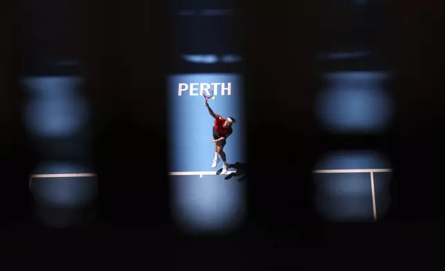 Taylor Fritz of the United States is seen through a grate in the roof of the stadium as he serves to Borna Coric of Croatia during their United Cup tennis match in Perth, Australia, Tuesday, Dec. 31, 2024. (AP Photo/Trevor Collens)