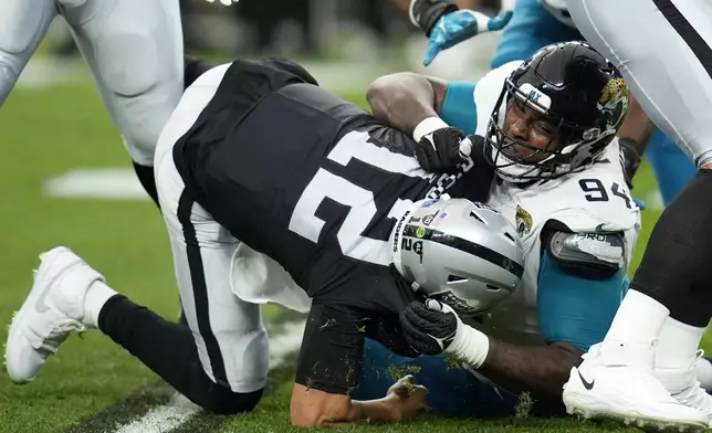 Jacksonville Jaguars defensive tackle Maason Smith (94) sacks Las Vegas Raiders quarterback Aidan O'Connell (12) during the first half of an NFL football game Sunday, Dec. 22, 2024, in Las Vegas. (AP Photo/John Locher)