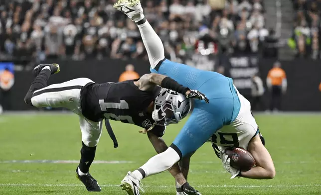 Las Vegas Raiders cornerback Jack Jones, left, takes down Jacksonville Jaguars tight end Luke Farrell during the second half of an NFL football game Sunday, Dec. 22, 2024, in Las Vegas. (AP Photo/David Becker)