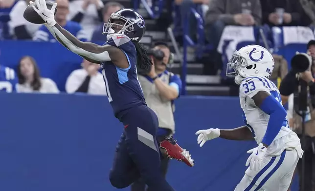 Tennessee Titans wide receiver Calvin Ridley, left, catches a pass for a touchdown over Indianapolis Colts cornerback Samuel Womack III (33) during the first half of an NFL football game Sunday, Dec. 22, 2024, in Indianapolis. (AP Photo/Michael Conroy)