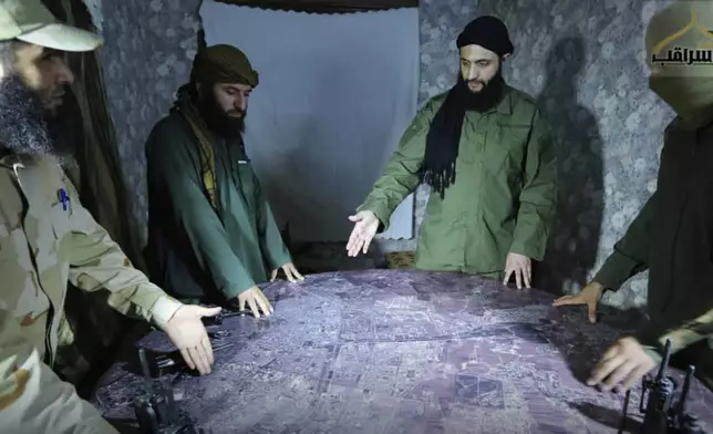 FILE - This undated photo released by a militant group in 2016, shows Abu Mohammed al-Golani, the leader of Syria's al-Qaida affiliate, second from right, discussing battlefield details with commanders in Aleppo, Syria. (Militant UGC via AP, File)