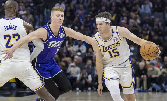 Los Angeles Lakers guard Austin Reaves (15) drives to the basket as forward LeBron James (23) sets a screen on Sacramento Kings guard Kevin Huerter (9) during the first half of an NBA basketball game Saturday, Dec. 21, 2024, in Sacramento, Calif. (AP Photo/Sara Nevis)