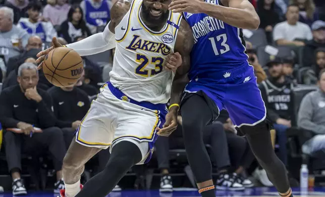 Los Angeles Lakers forward LeBron James (23) drives to the basket with Sacramento Kings forward Keegan Murray (13) defending during the first half of an NBA basketball game, Saturday, Dec. 21, 2024, in Sacramento, Calif. (AP Photo/Sara Nevis)